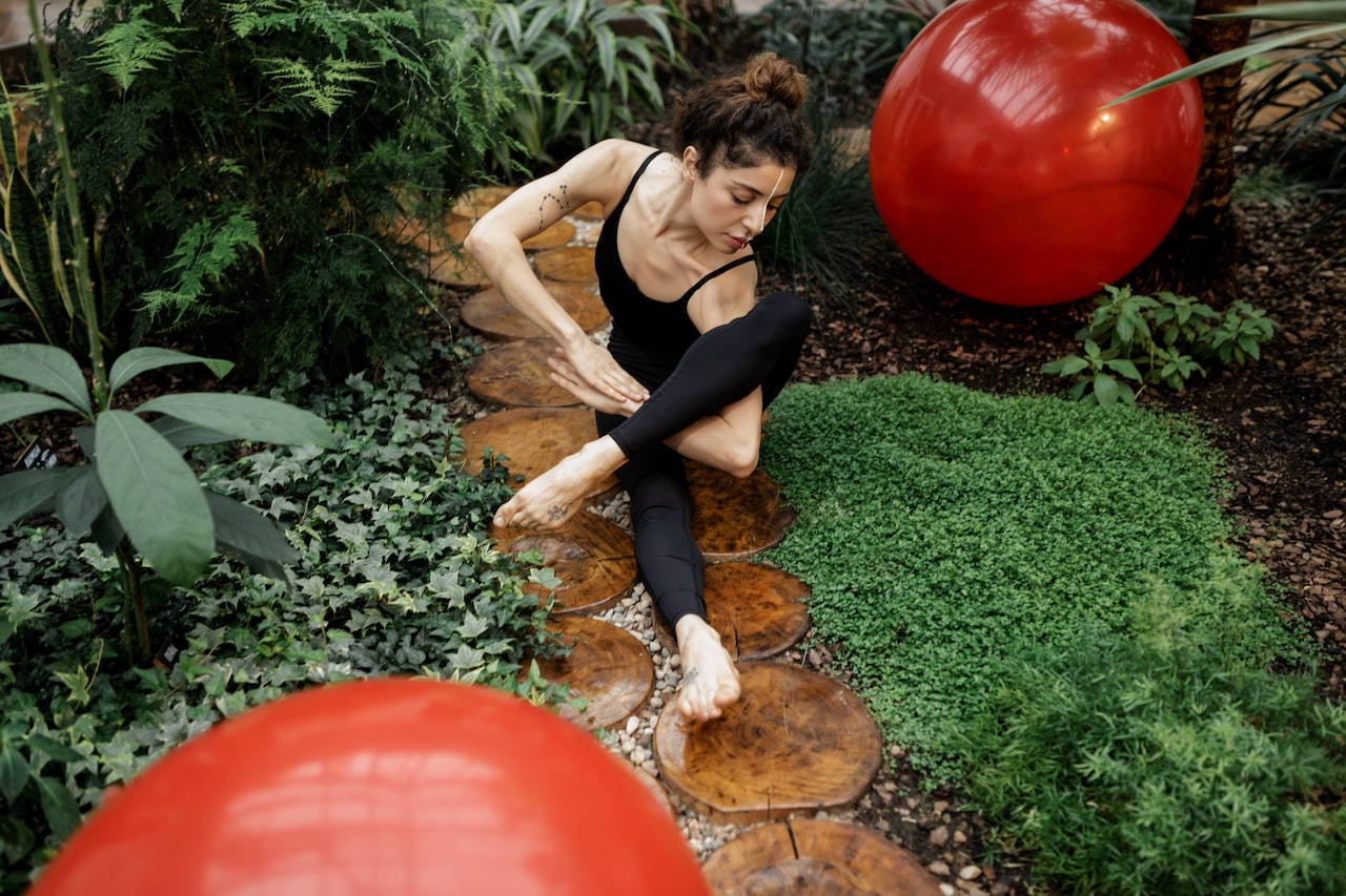 Woman is doing yoga in her garden space
